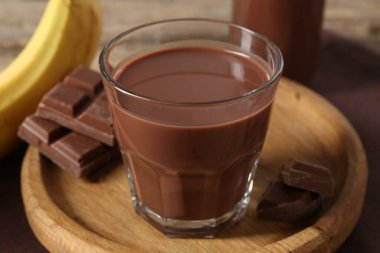 Lezzetli çikolatalı süt, parçalar ve muz masada, yakın plan.