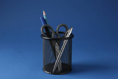 Koyu mavi arkaplanda kalem tutacağında farklı bir kırtasiye