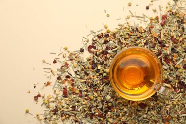 Cam fincanda nefis bitki çayı ve bej arka planda kuru yapraklar, üst manzara. Metin için boşluk