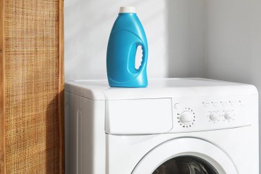 Çamaşır makinesinde bir şişe yumuşatıcı.