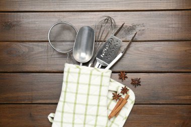 Farklı mutfak aletleri fırın eldiveni, tarçın ve anason yıldızları ahşap masa, düz yatıyordu.