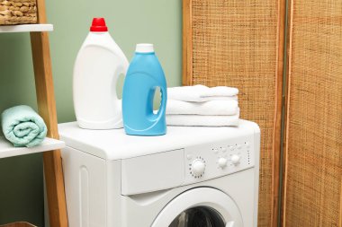 İçerideki çamaşır makinesinde yumuşatıcı ve havlu şişeleri.