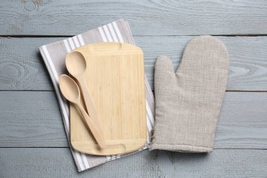 Farklı mutfak gereçleri ve fırın eldivenleri açık gri ahşap masa, düz yatıyordu.