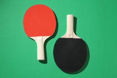 Yeşil arkaplanda pinpon raketleri, üst görünüm