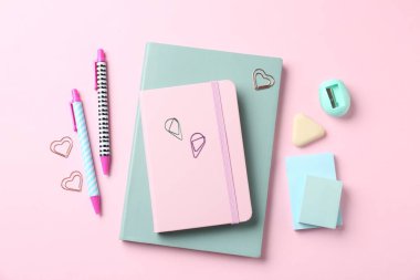 Pembe arka planda kalemler ve diğer kırtasiyeler, düz konum