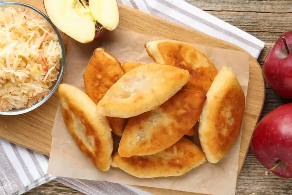 Lezzetli kızarmış pirinçler (doldurulmuş turtalar) ve ahşap masa üzerinde elmalar, düz uzanmış