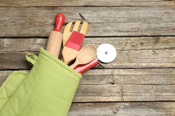 Ahşap masadaki fırın eldiveninde farklı mutfak aletleri, üst manzara. Metin için boşluk
