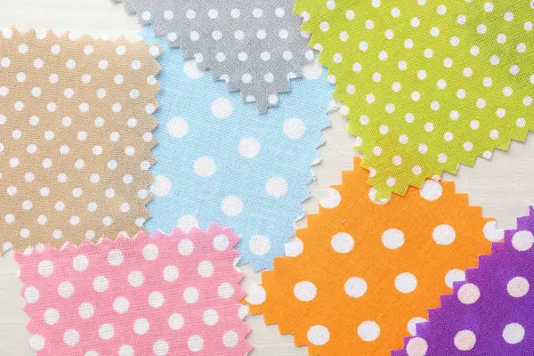 Beyaz ahşap masa üzerinde farklı kumaş örnekleri, düz yatıyordu.