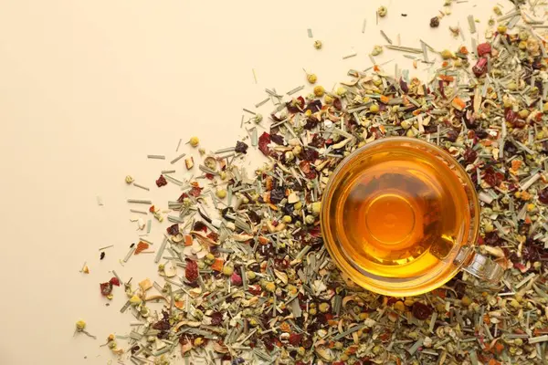 Cam fincanda nefis bitki çayı ve bej arka planda kuru yapraklar, üst manzara. Metin için boşluk