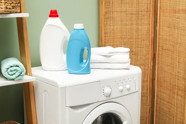 İçerideki çamaşır makinesinde yumuşatıcı ve havlu şişeleri.