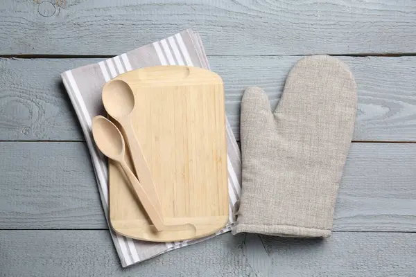 Farklı mutfak gereçleri ve fırın eldivenleri açık gri ahşap masa, düz yatıyordu.