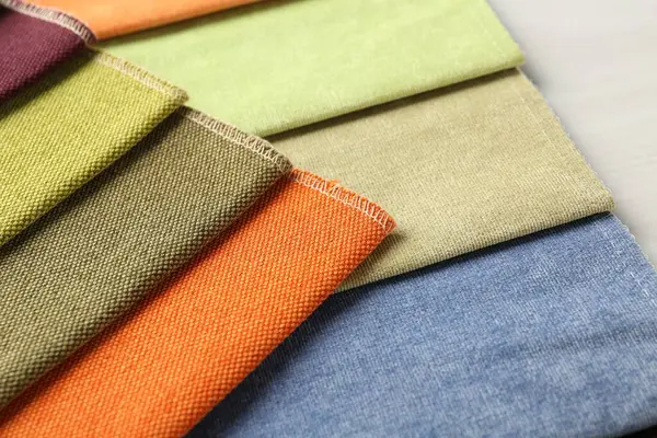 Açık ahşap masadaki farklı kumaşlardan örnekler.