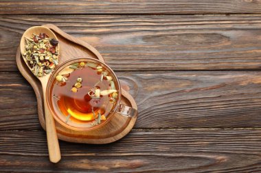 Cam bardakta romatik bitki çayı ve tahta masada kuru yapraklar, üst manzara. Metin için boşluk