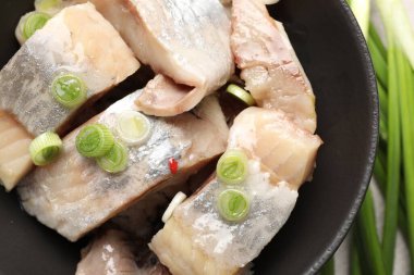 Masada yeşil soğanlı lezzetli ringa balıkları, yakın plan.