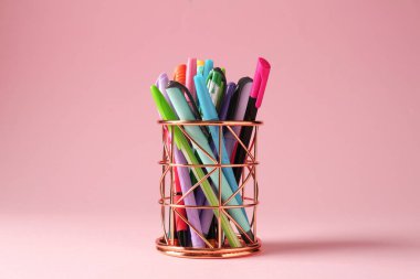 Pembe arka planda kalem tutacağında farklı bir kırtasiye