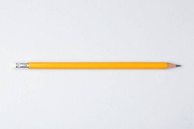 Gri arkaplanda keskin bir grafit kalem, üst görünümde.