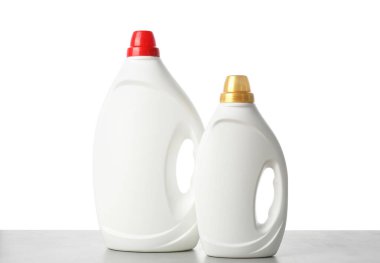 Beyaz arkaplana karşı gri masada yumuşatıcı şişeler