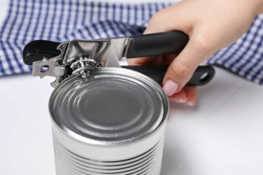 Beyaz masada konserve açacağıyla konserve açan kadın, yakın çekim