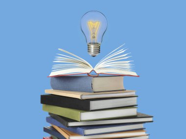 Açık mavi arka plandaki kitap yığınının üzerinde havadaki ampul. Fikir ve bilgi