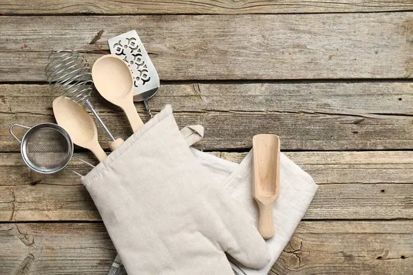 Ahşap masadaki fırın eldiveninde farklı mutfak aletleri, üst manzara. Metin için boşluk