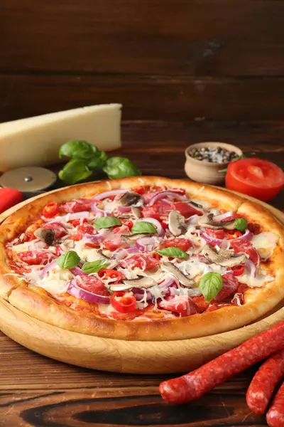 Lezzetli pizza, füme sosis ve ahşap masa malzemeleri, yakın plan.
