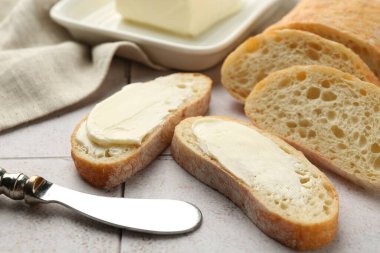 Üzerinde tereyağı ve bıçak bulunan ekmek parçaları, yakın plan.