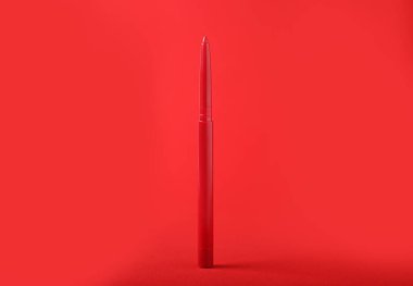 Kırmızı arkaplanda bir göz kalemi, yakın plan.