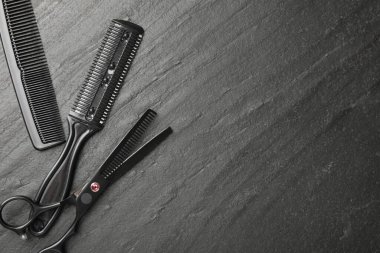 Siyah masada farklı berber aletleri var, düz yerde. Metin için boşluk