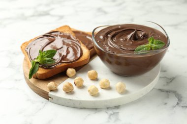 Çikolata, naneli ve fındıklı beyaz mermer masa, yakın plan.