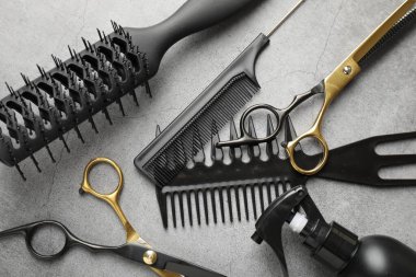 Gri masada farklı kuaförlerin aletleri var.