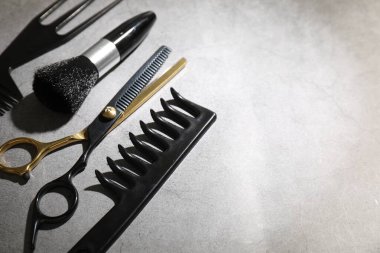 Gri masadaki farklı kuaför aletleri, yakın plan. Metin için boşluk
