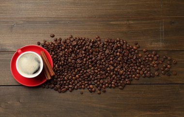 Aromatik kahve fincanda, fasulye ve tarçın ahşap masada, düz yerde.