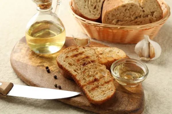 Zeytinyağlı tost ekmeği, diğer baharatlar ve bıçak beyaz desenli masada, yakın plan.