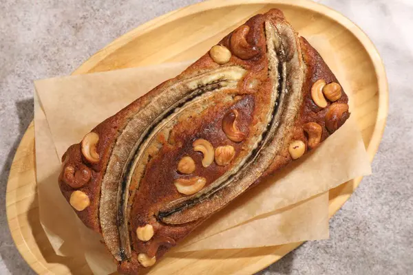 Ev yapımı muz ekmeği, fındıklı gri masa, üst manzara.