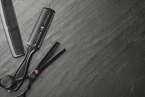 Siyah masada farklı berber aletleri var, düz yerde. Metin için boşluk