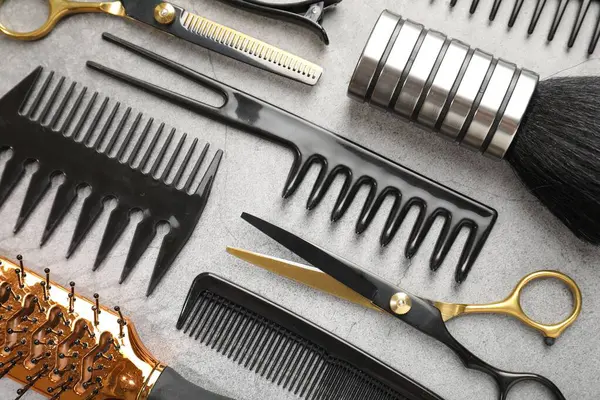 Gri masada farklı kuaförlerin aletleri var.