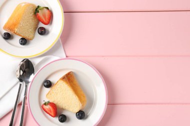 Pembe ahşap masa üzerinde böğürtlenli lezzetli kek parçaları. Metin için boşluk