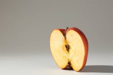 Hasarlı elmanın yarısı açık gri arka planda. Metin için boşluk