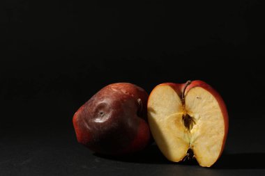 Siyah arka planda zarar görmüş kırmızı elmalar. Metin için boşluk