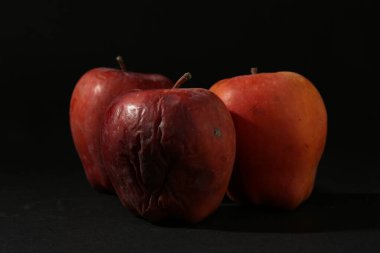 Siyah arkaplanda hasarlı kırmızı elmalar, yakın plan