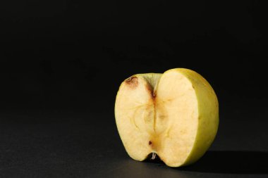 Hasarlı elmanın yarısı siyah arka planda. Metin için boşluk