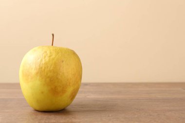 Ahşap masada çürük yeşil bir elma. Metin için boşluk