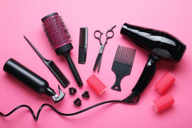 Pembe arka planda farklı kuaför aletleri, düz yatış