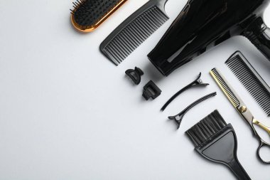 Beyaz arka planda farklı kuaför aletleri, düz yatış. Metin için boşluk
