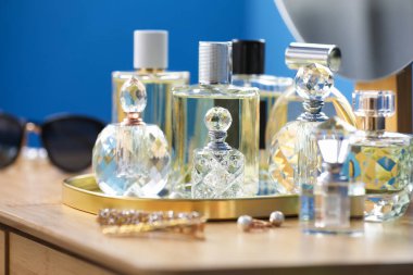 İçerideki ahşap masada parfüm şişeleri.