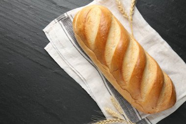 Siyah desenli masaya bir somun ekmek ve sivri uçlu çivi. Metin için boşluk