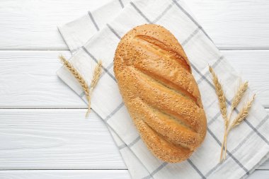 Taze ekmek somunu ve çiviler beyaz ahşap masada, düz yerde. Metin için boşluk