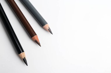 Beyaz arka planda üç farklı kaş kalemi, üst manzara. Metin için boşluk