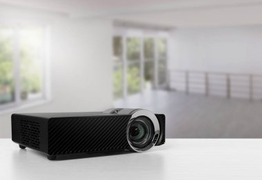 Beyaz masadaki modern video projektörü.