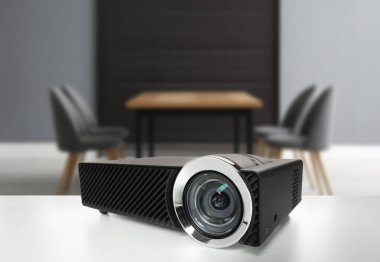 Konferans odasındaki beyaz masada modern video projektörü